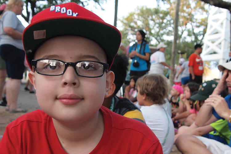 A boy wearing glasses and a red hat.