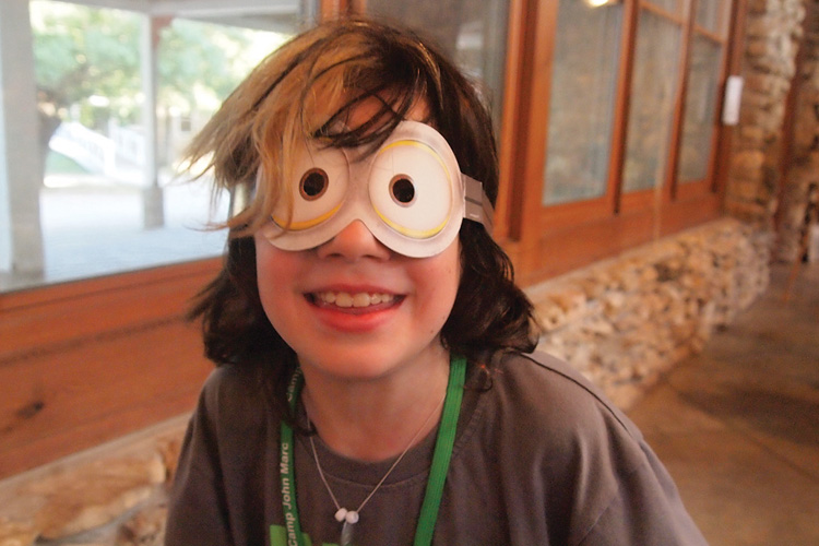 A young boy with fake eyes on his face.