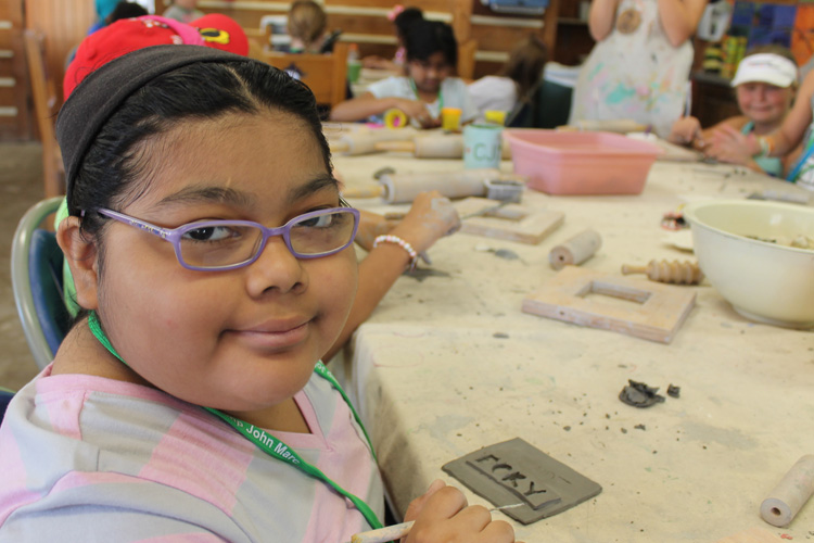 A girl with glasses is sitting at a table