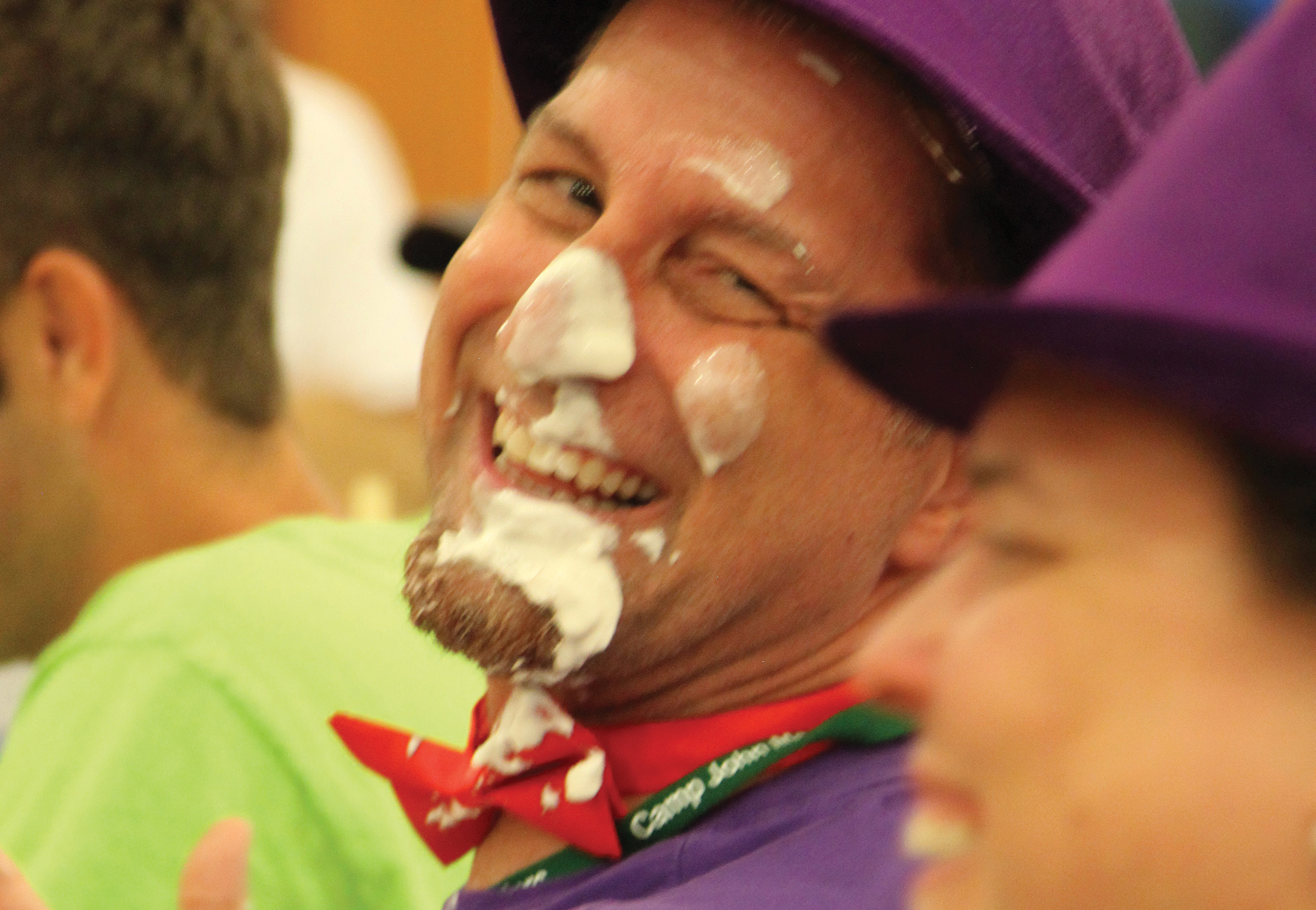 A man with a purple hat and white face paint.