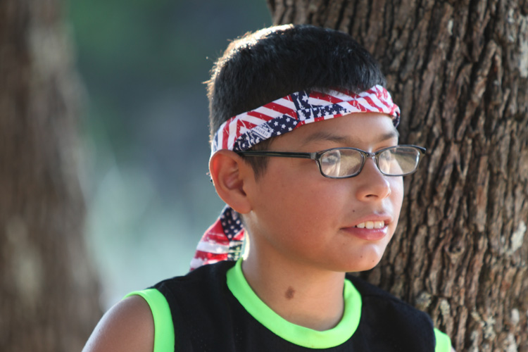 A boy wearing glasses and a bandana around his head.