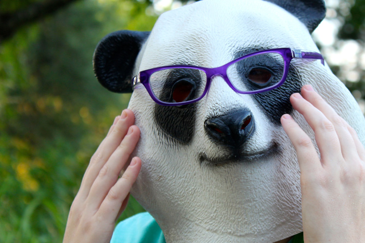 A panda bear mask with purple glasses on it.