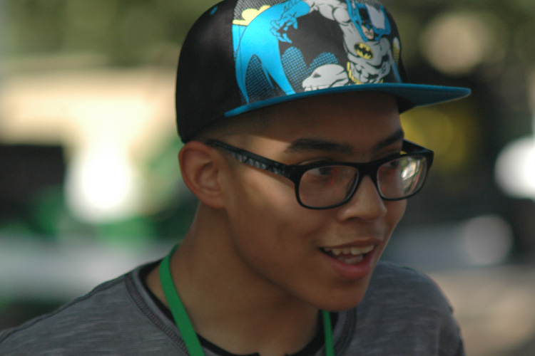 A young man wearing glasses and a batman hat.