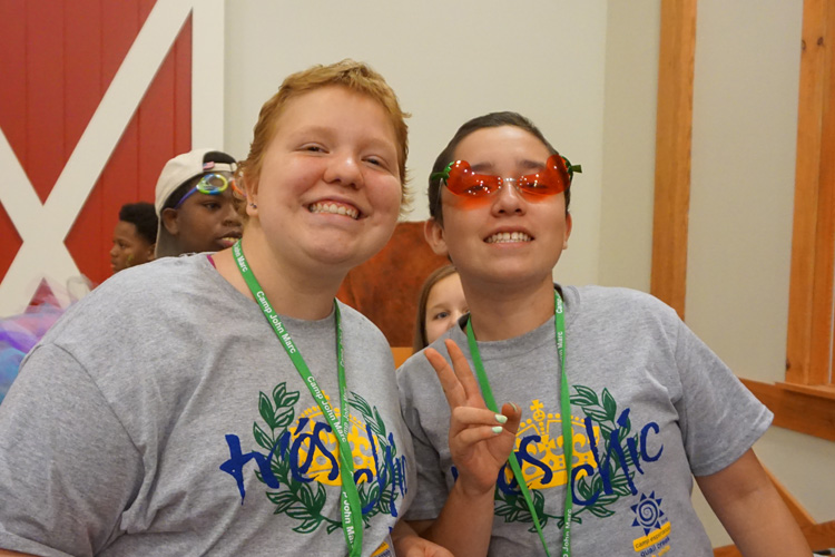 Two girls wearing glasses and smiling for the camera.