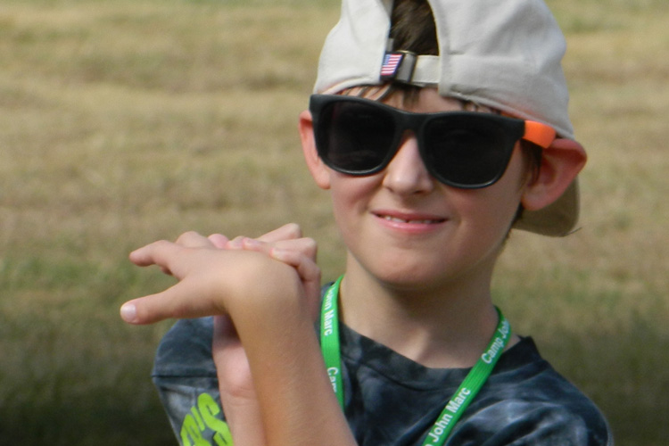 A boy wearing sunglasses and a hat