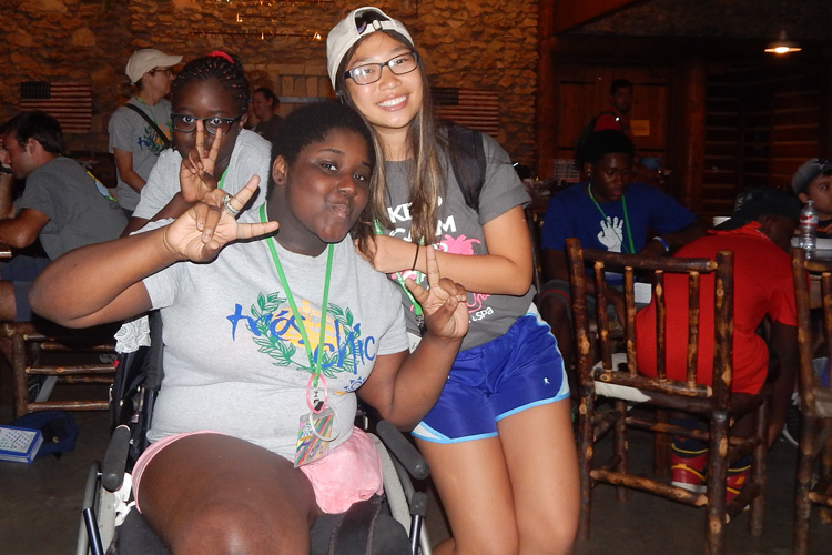 Two girls posing for a picture with their hands in the air.