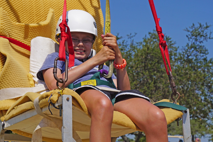 A girl in a helmet is on a swing.