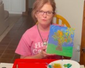 A woman holding up an image of a tree.