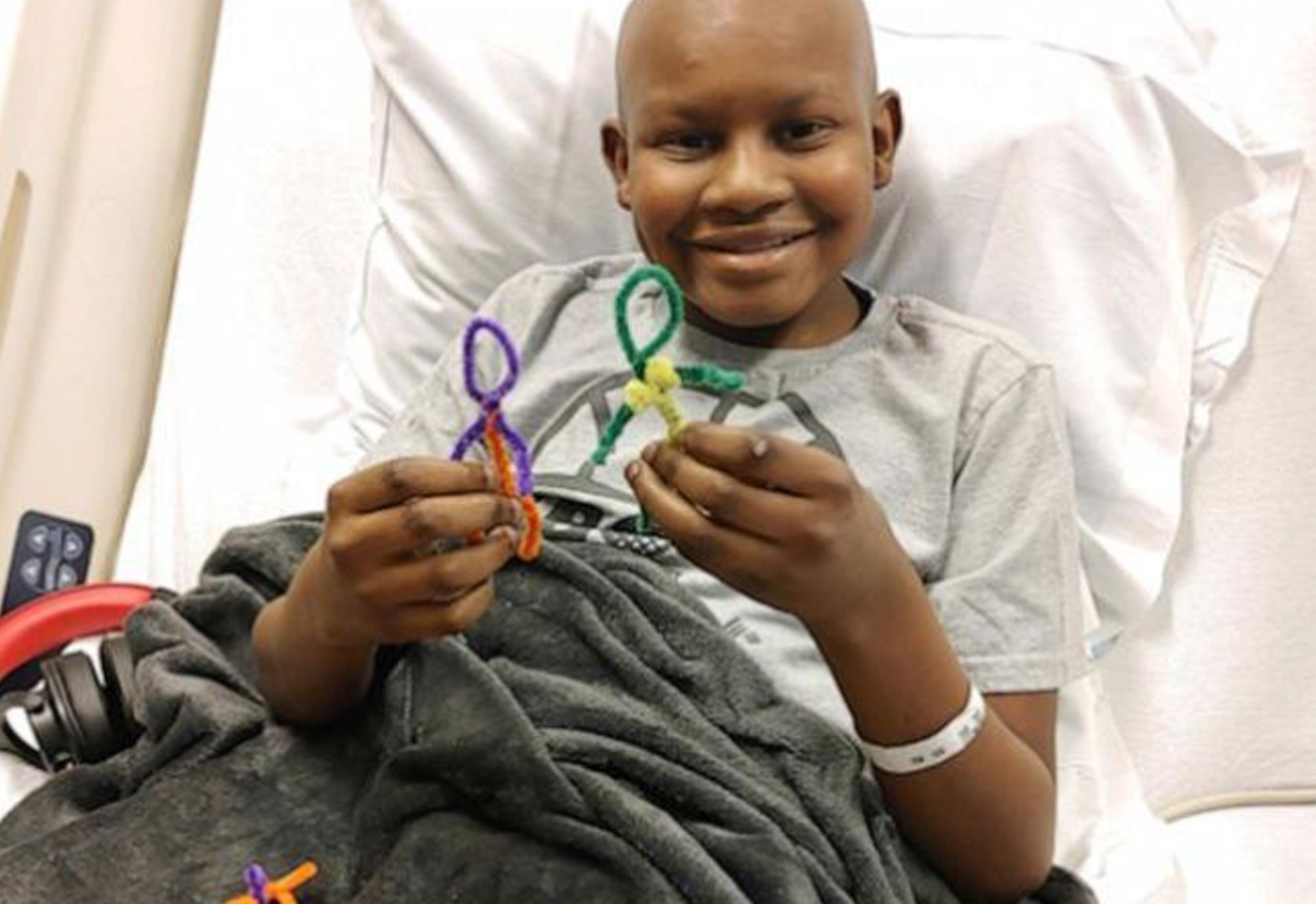 A young boy is holding some colorful scissors.