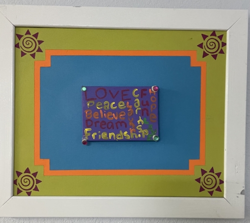 A picture frame with a colorful word art piece.