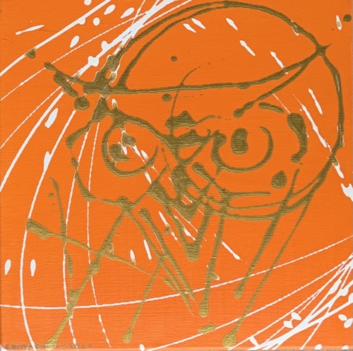 A drawing of a face on orange paper.