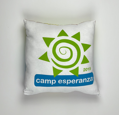 A pillow with the camp esperanza logo on it.