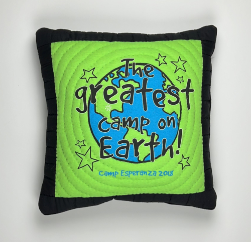 A pillow with the words " camp on earth !" written in it.