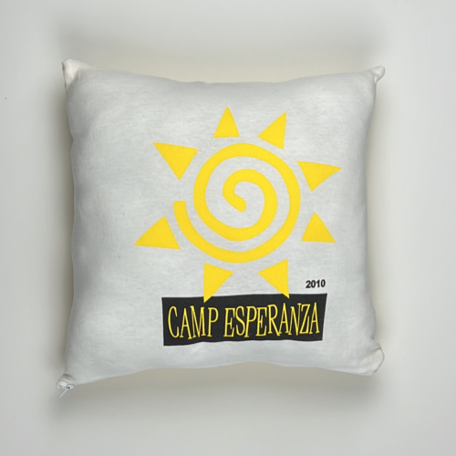 A pillow with the camp esperanza logo on it.