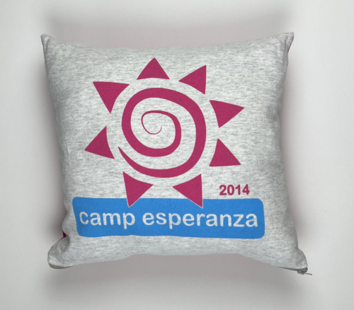 A pillow with the camp esperanza logo on it.