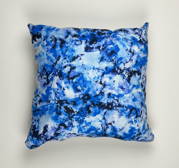 A blue pillow with some white and black spots
